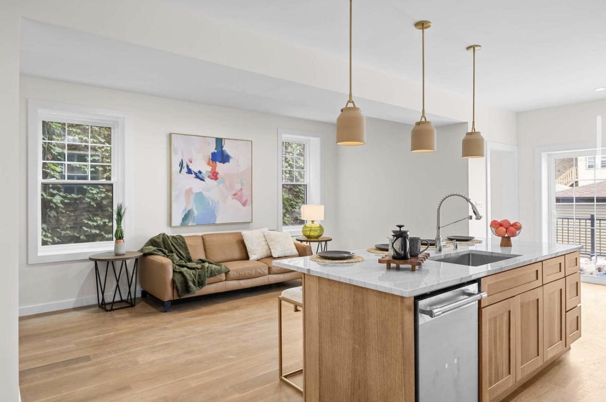Open living room with brass pendant lights over island